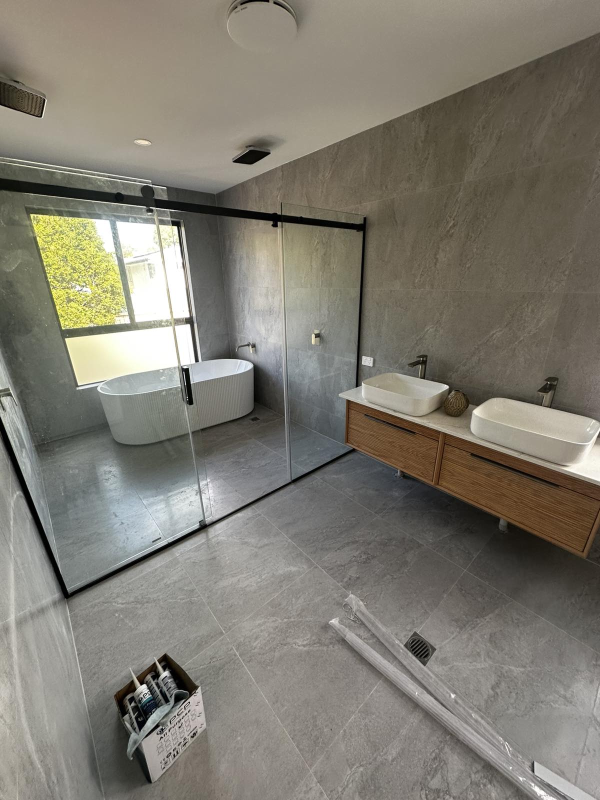Ensuite bathroom with walk-in glass shower, freestanding bath and timber vanity