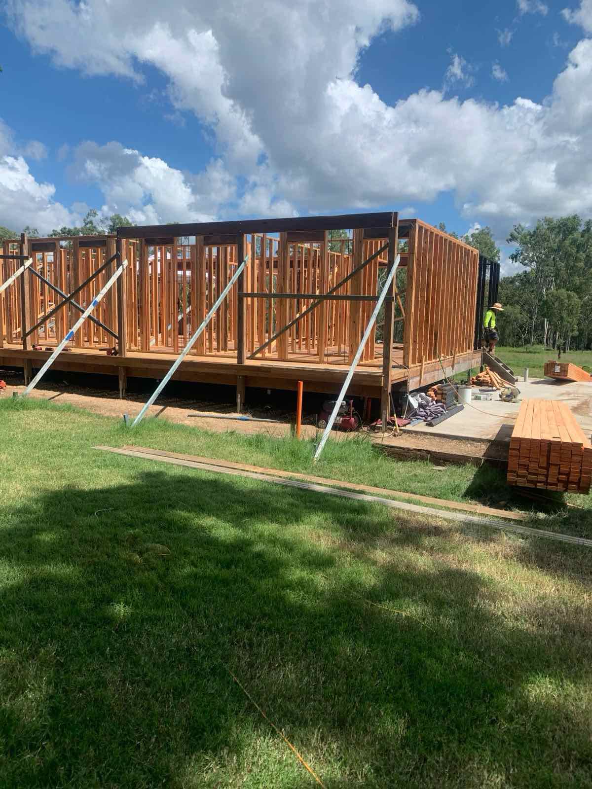 Two-storey home extension framing with a carpenter securing a steel post